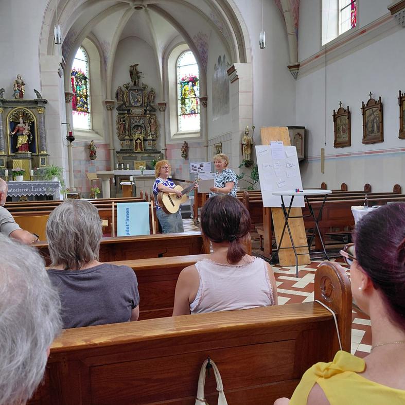 Gäste in den Bänken der Kirche hören dem Gesang zu